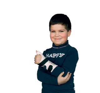 Jeune garçon souriant portant un pull "HAPPY" et une attelle de poignet. Il fait un pouce levé.